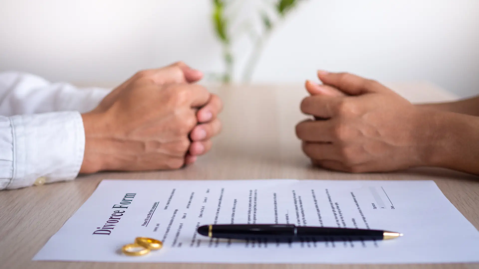 couple discussing divorce agreement over legal form and wedding rings