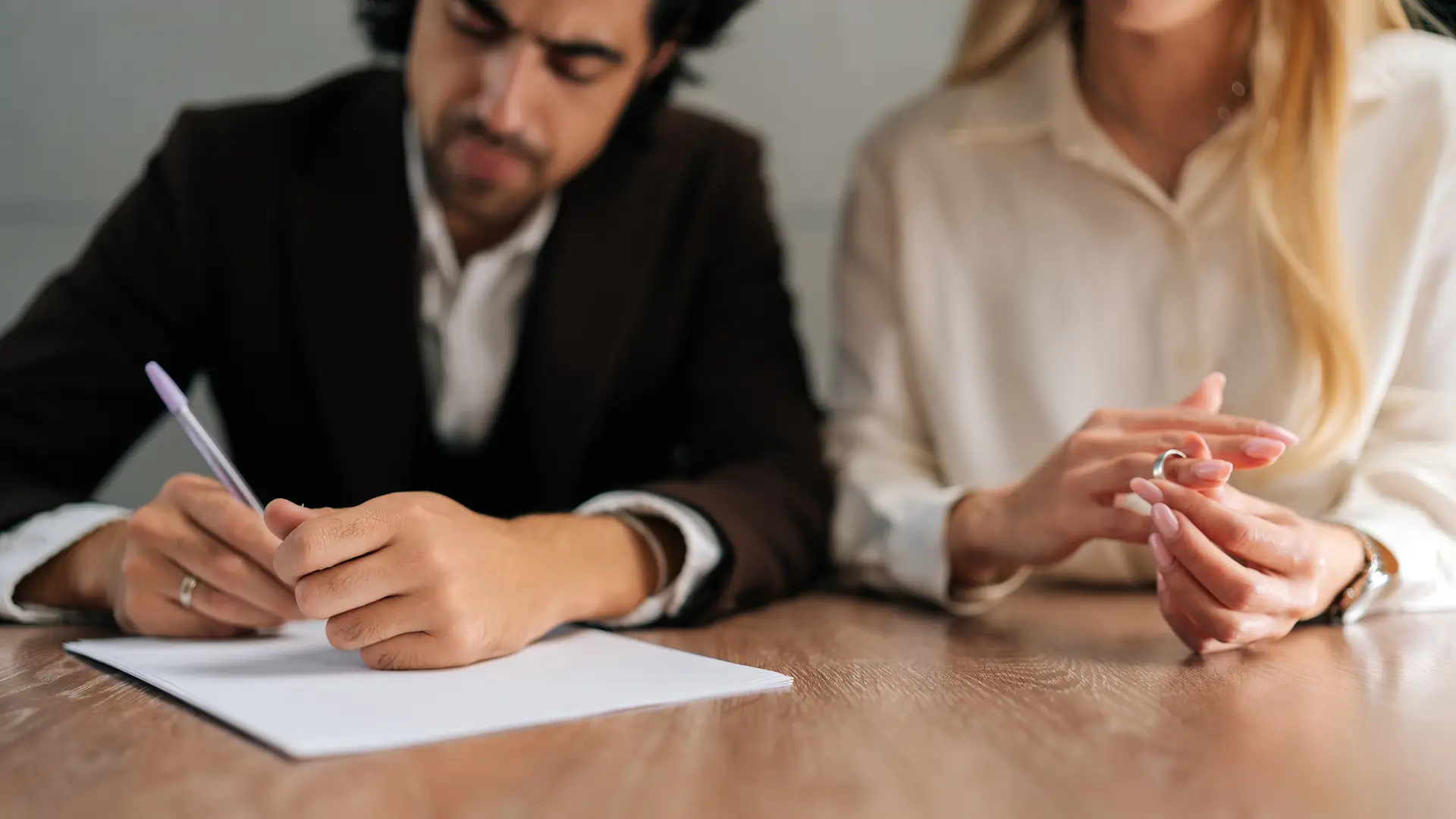couple signing divorce papers removing wedding ring legal separation concept